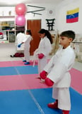 niños en posición de respeto karateca esperando instrucciones de entrenamiento karateca