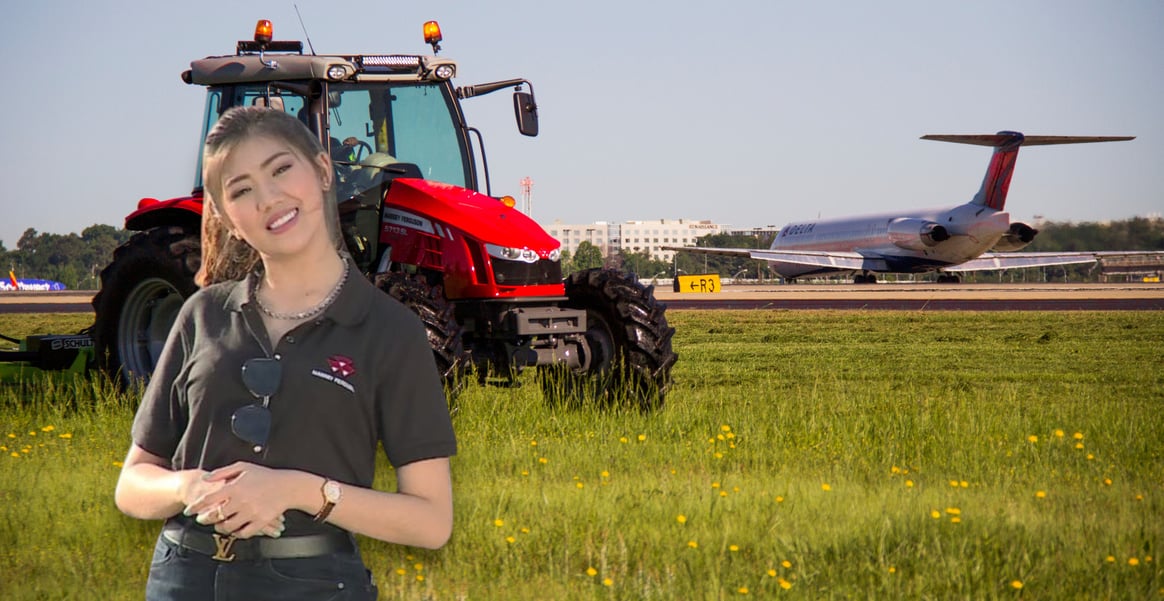 a woman in a black shirt and jeans standing in front of a tractor