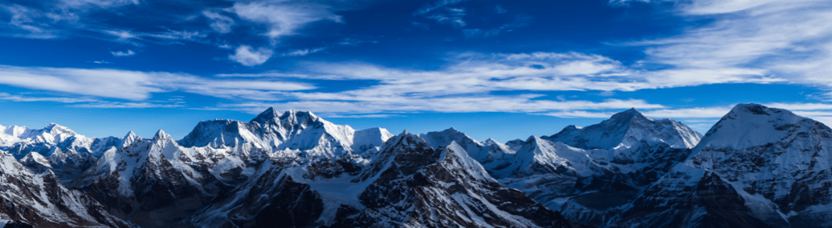 a mountain range with a blue sky and clouds