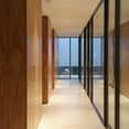 pasillo con mamparas de cristal y paredes revestidas en madera
