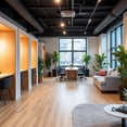 interior de coworking con suelo de madera, techo pintado en negro y cabinas telefonicas 