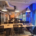 oficina abierta con paredes revestidas en madera y luces de neon