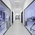 pasillo oficina Zeiss con mamparas de cristal y techo suspendido