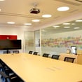 Sala de reuniones con mampara de cristal y paneles acusticos en las paredes