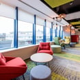 vista interior oficina Groupon - comodos sofas y mesas bajas y paneles acusticos 