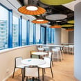 Sala de estar con mesas redondas, sillas y paneles acusticos (Resting area with round tables, chairs and acoustic panels)