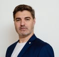 Consultor de marketing digital profesional con blazer azul, fondo blanco.
