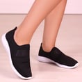 pés e pernas de uma mulher com tênis preto e branco