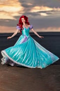 Ariel de La Petite Sirène dans un cosplay, faisant tourner sa robe dans un mouvement gracieux