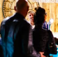 a man and woman standing in front of a clock