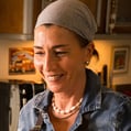 a woman in a denim jacket and pearls