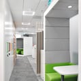 vista interior de oficina mBank con alfombra gris y techo modular suspendido