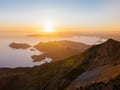 a mountain scene with a sunset over the ocean