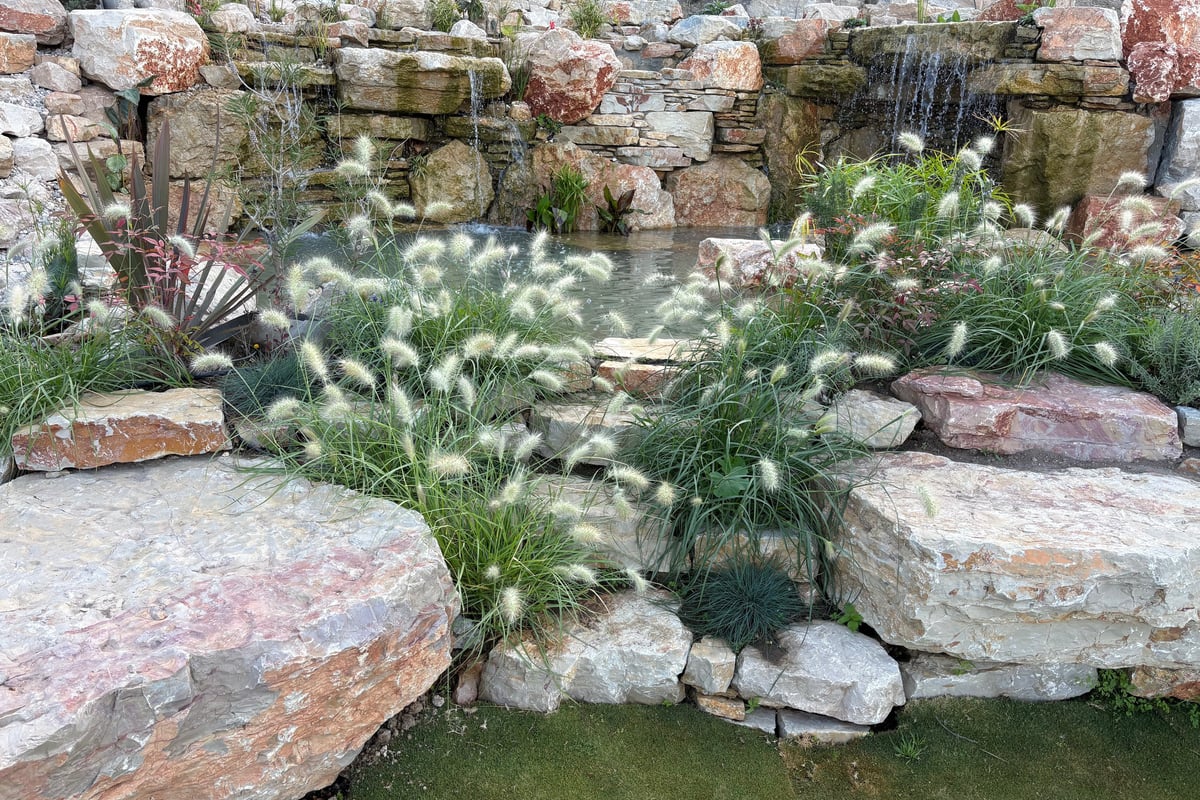Natural stone steps lead to plunge biopool with waterfalls and adjacent lily pond — Lisbon, Aqua Vitae