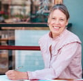 a woman sitting at a table with a pen and paper