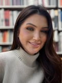 a woman with long hair and a turtle neck sweater