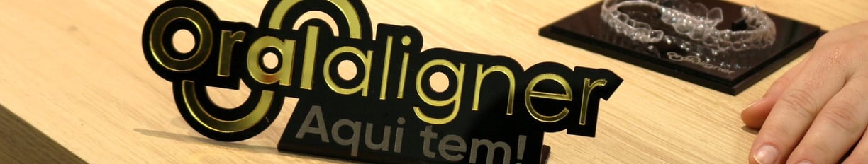 a woman sitting at a table with a invisible teeth aligner in front of her