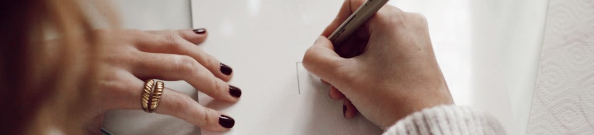 a woman is writing on a piece of paper