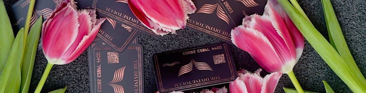 Luxury black business cards for The Divine Touch, styled with pink tulips on a dark background.