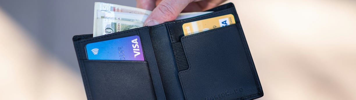 a person holding a wallet with a credit card