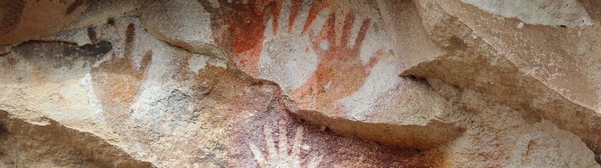 a rock wall with a hand painted on it