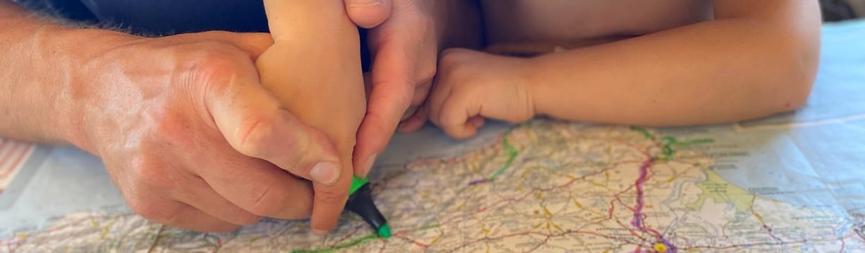 a man and a child are looking at a map