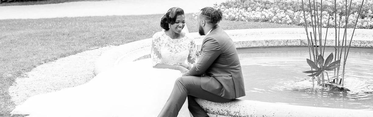 un couple assis sur une fontaine se regardant avec amour