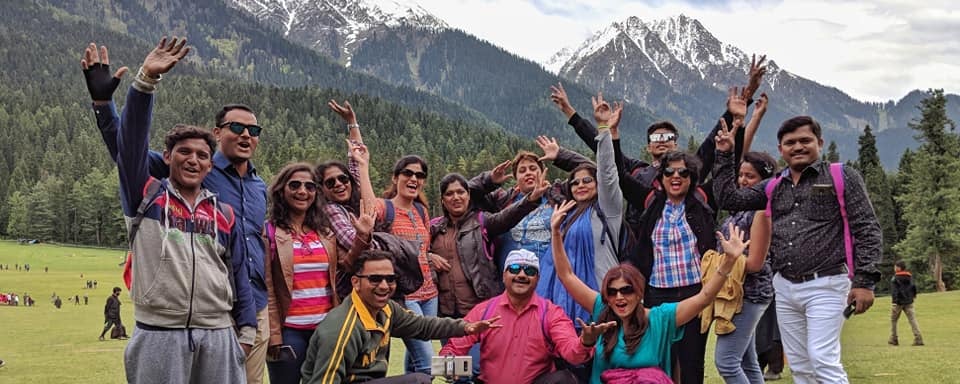 a group of people standing in a field with their hands up