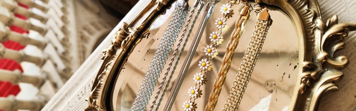Pulseiras diferentes sob espelho dourado.