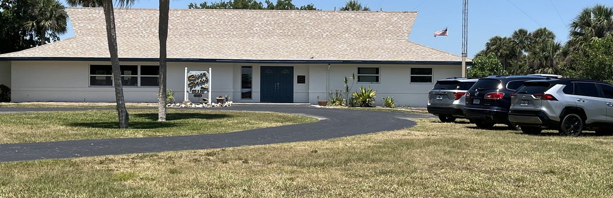 a clubhouse with cars parked in front of a clubhouse