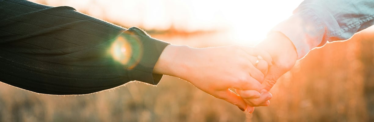 Close up of man and woman holding hands. 