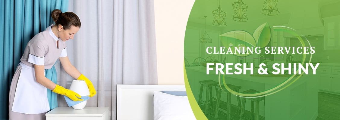a maid maid cleaning a bed in a hotel room