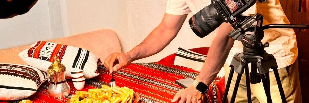 a man is taking a picture of a plate of food