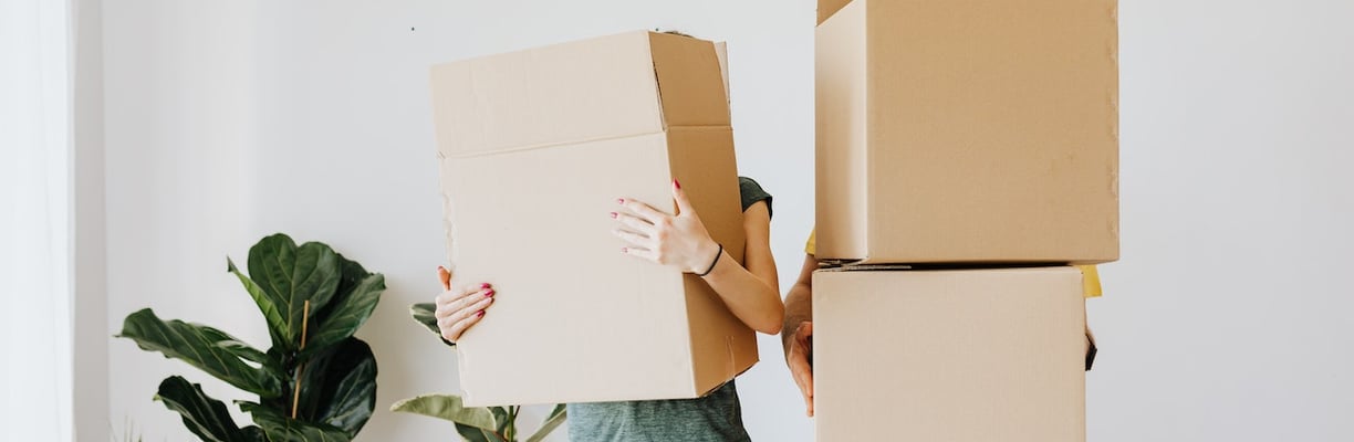 Hombre y mujer sosteniendo cajas con cajas encima: Soluciones de Empaque | BeeTheBox.mx