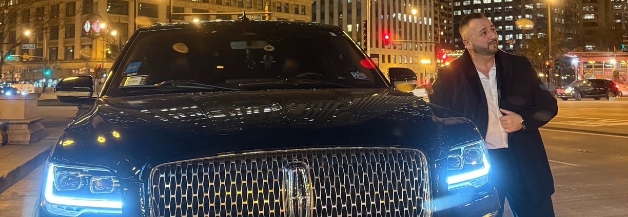 Lucian in front of a Lincoln SUV in Chicago