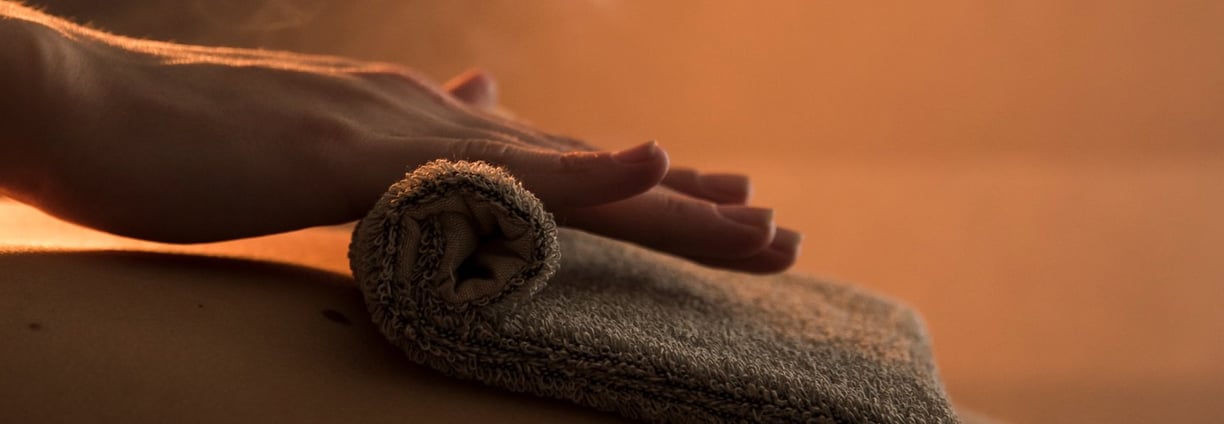 Massage du dos d'une femme avec serviette chaude
