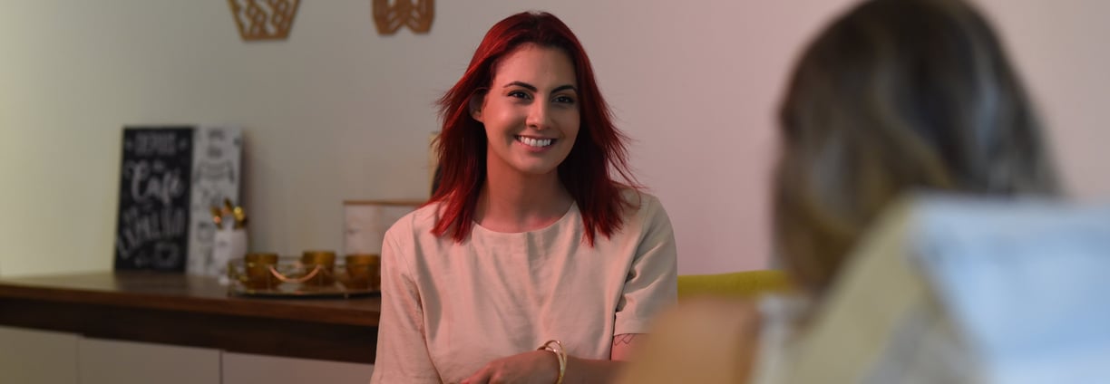 Palloma está em uma sessão presencial com um paciente, conduzindo a conversa com empatia e profissio