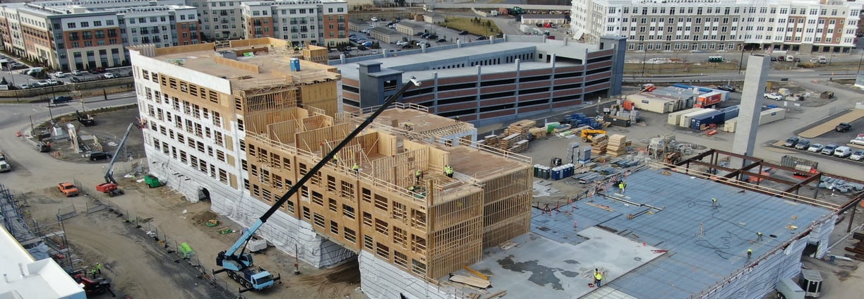 a large Wood Paneling Frame building with a crane in the foreground