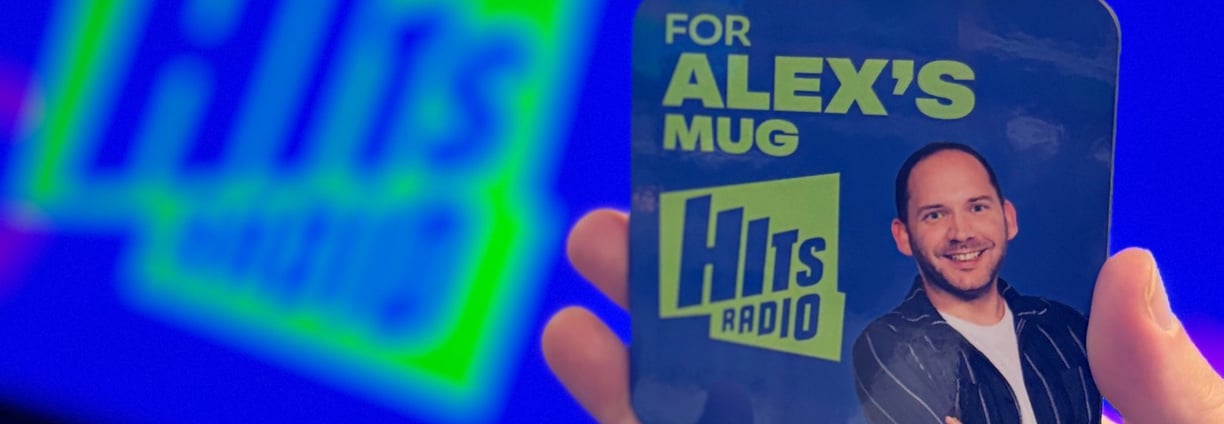 A Hits Radio drinks coaster that says 'for Alex's mug' on it.