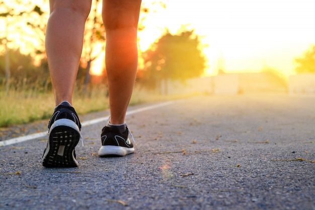 a person walking on a road with a person wearing a pair of sneakers