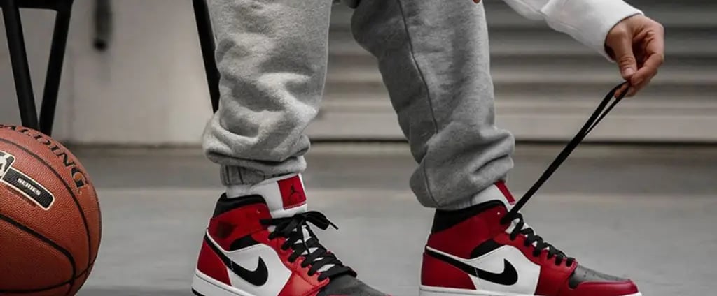 Air Jordan 1 Mid 'Chicago Black Toe' sneakers in black, white, and red with high-top design and Nike Swoosh