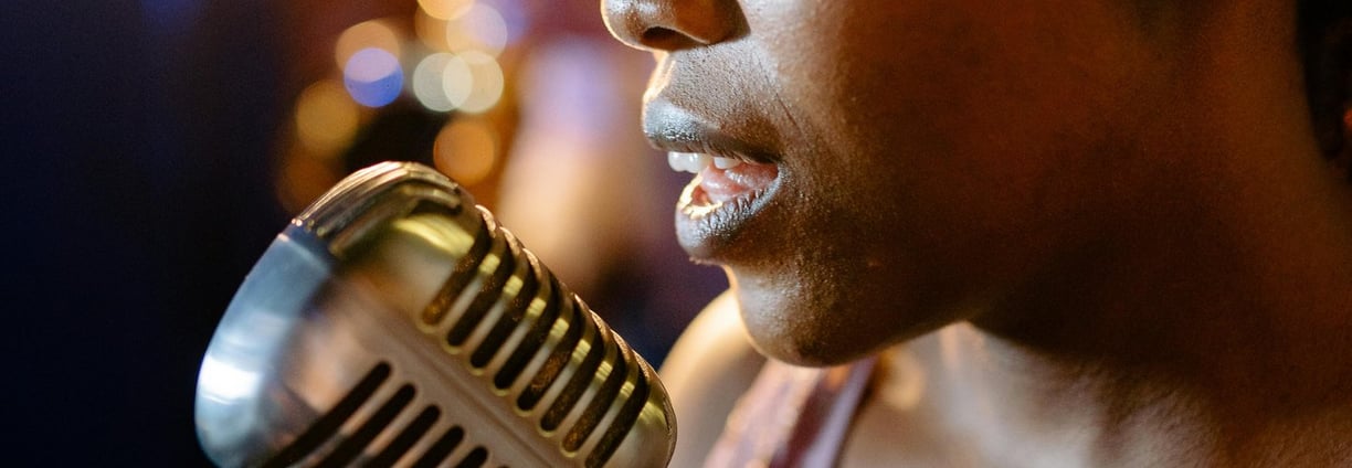 a woman in a sequinous dress is holding a microphone