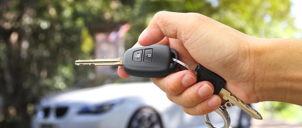 a person holding a car keychain in their hand