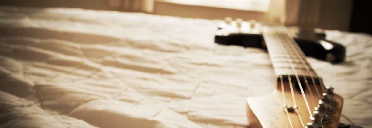 Electric guitar on bed