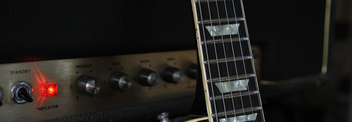 A Les Paul guitar leaning against a Marshall amplifier.