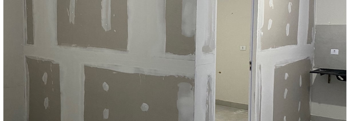 a room with a wall of drywalled walls and a door