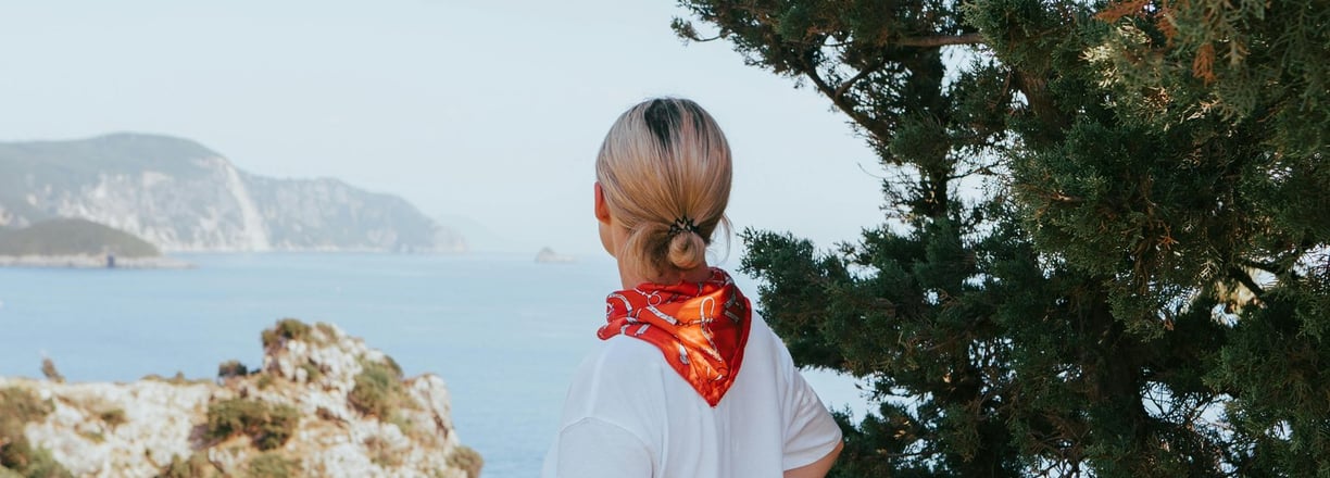 a woman standing on a hill overlooking the ocean