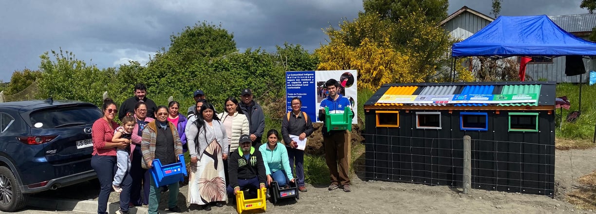Equipo de EcoRumbo junto a comunidad en Curaco de Vélez durante entrega punto limpi
