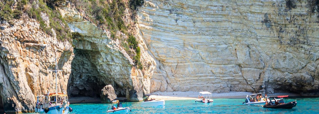 a boat in the water near a cliff