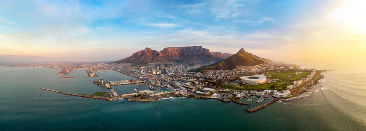 Aerial view of Cape Town with Table Mountain, city bowl, and coastline at sunrise — ideal for landscape photography.